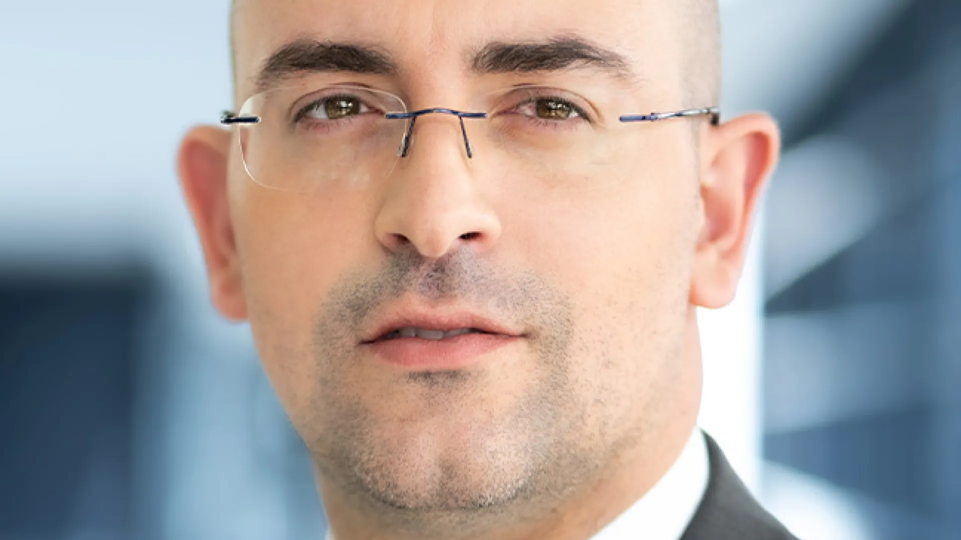 a man wearing glasses and a suit